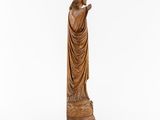a wooden statue of jesus holding a cross on a white background