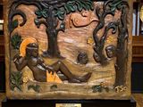 une sculpture représentant une femme assise sous un arbre