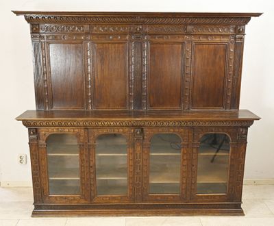 une bibliothèque ancienne en chêne avec des portes vitrées et une étagère en bois