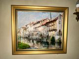 a painting hanging on the wall above a toilet in a bathroom