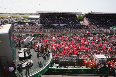 une foule nombreuse dans un stade, brandissant des drapeaux rouges