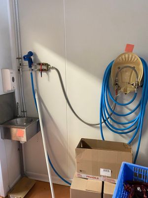 un tuyau bleu fixé au mur à côté d'un évier