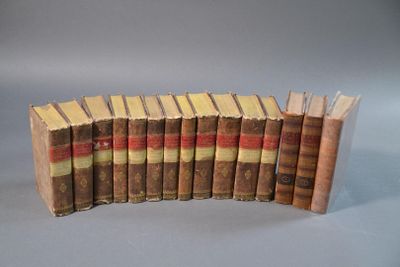 plusieurs vieux livres alignés les uns à côté des autres sur une surface grise