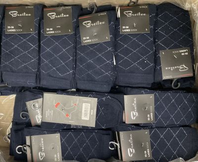 plusieurs paires de chaussettes pour homme dans une boîte sur laquelle sont apposées des étiquettes
