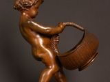 bronze statue of a boy with a basket on a wooden base