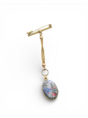 a close up of a gold plated necklace with a blue stone