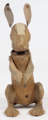 une sculpture en bois représentant un lapin assis sur ses pattes arrière