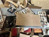 a pile of assorted items on a table with a sign on it