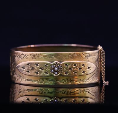 a close up of a gold bracelet with a chain around it