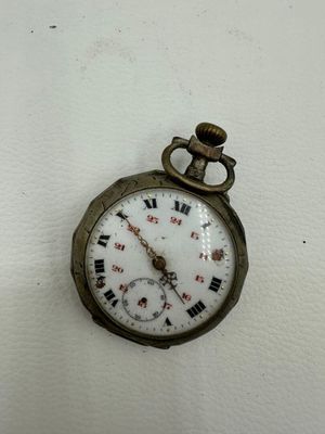 une petite montre de poche ornée de chiffres romains