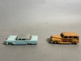 two toy cars sitting next to each other on a table