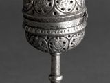 an old silver object with a bird on top of it