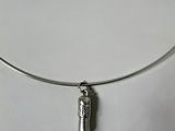 a close up of a silver necklace with a bottle on it