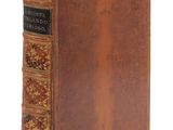un vieux livre à la couverture brune et à la bordure dorée