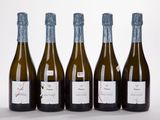quatre bouteilles de vin sont alignées sur une surface blanche