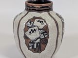 a white vase with a brown and black design on it