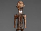 a wooden figure of a man with a label on his chest