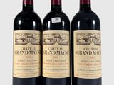 trois bouteilles de vin rouge posées l'une à côté de l'autre sur une surface blanche