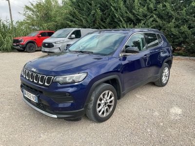 a blue jeep compass parked in a parking lot