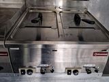 stainless steel counter top with three burners on each side of it