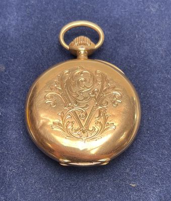 an old gold pocket watch with a chain on a blue surface