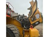 a picture of a large yellow truck with a big wheel