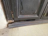 a cat that is sitting on the floor in front of a door