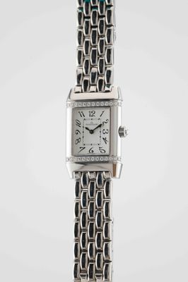 a close up of a wrist watch with a chain around it