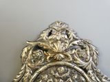 a silver mirror with a bird on it on a wall