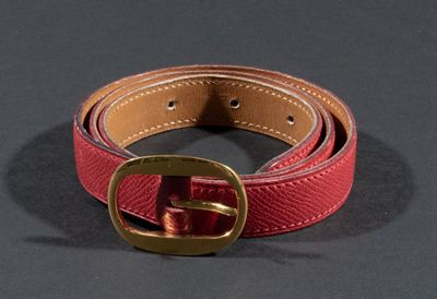 HERMES. Ceinture en cuir rouge boucle ovale dorée.