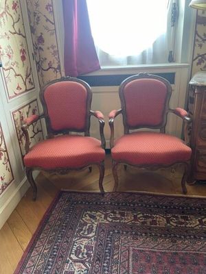 deux chaises rouges dans une pièce où il y a un tapis au sol