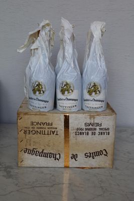 three bottles of wine sitting on top of a wooden box
