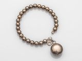 a close up of a bracelet with a ball on it