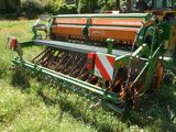 un tracteur immobilisé dans l'herbe, avec une charrue attelée derrière lui