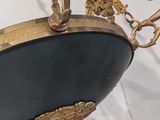 a black and gold bowl with a pair of scissors hanging from it