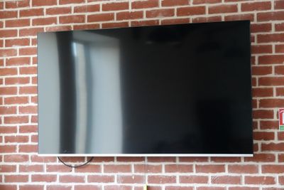 un téléviseur à écran plat fixé à un mur de briques