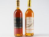 two bottles of wine sitting next to each other on a white surface