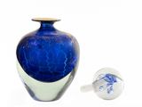 a blue glass vase and a white vase on a white surface