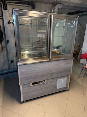 une vitrine au milieu d'une pièce avec une chaise rouge dans le coin