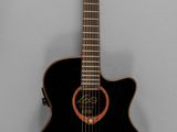 an image of a black acoustic guitar hanging on a wall