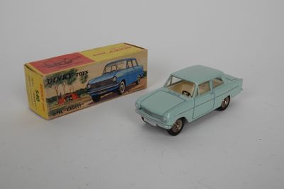 une petite voiture miniature posée à côté d'une boîte sur une surface blanche