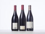 three bottles of wine are lined up on a table