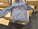 a pile of boxes and a blue hoodie on the floor