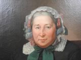portrait of a woman in a black dress with a white bonnet and green scarf