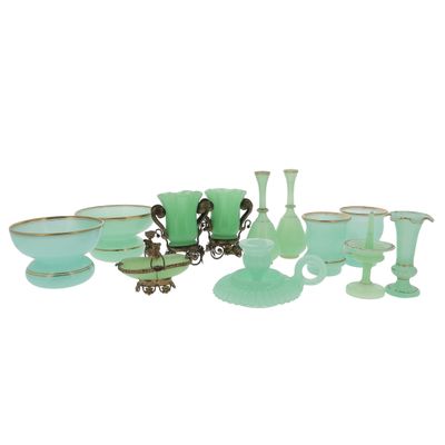 a group of green glass vases and bowls on a table