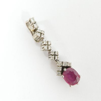un gros plan d'un pendentif en rubis et diamants sur fond blanc