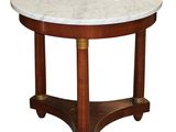 une table ronde au plateau en marbre, avec des pieds et un piètement en bois