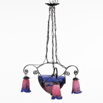 un gros plan sur un lustre auquel sont suspendues trois lampes