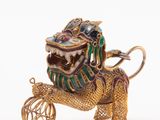 an image of a gold and enamel dragon with a ball