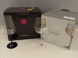 two wine glasses sitting next to a box on a table